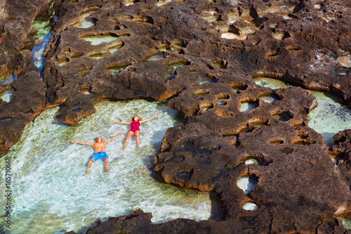 Family beach holiday lifestyle. Happy couple relax in natural sea pool at Angel’s Billabong on Pasih Uug. Best travel destinations on Bali island. Nusa Penida day tour popular place. Leisure activity. photo