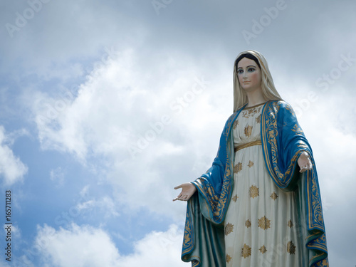 The Blessed Virgin Mary Statue blue sky background.