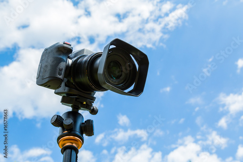 Digital camera closeup on a background of sky and clouds. Shooting on location and nature.