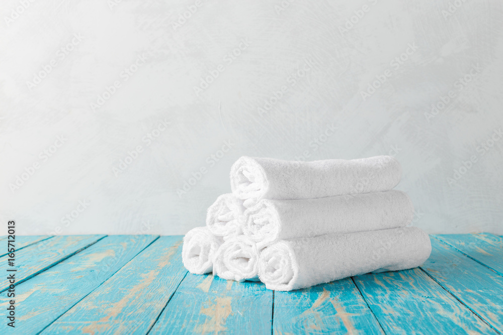 Stack of bath towels on wooden table with copy space Stack of bath towels on wooden table with copy space