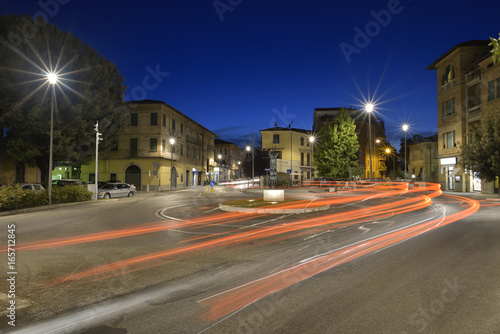 Car light trails on the crossroad during night in the city of Umbertide, Italy