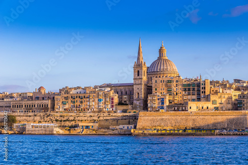 Valletta, Malta - The beautiful Saint Paul's Cathedral and the ancient walls of Valletta in the morning with clear blue sky