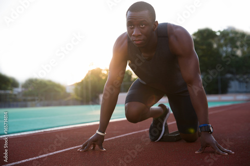 Young african male athlete about to start a sprint race