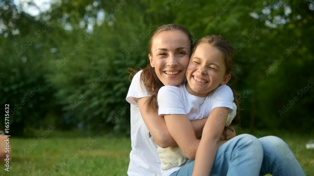 Kind female volunteer embracing little girl tightly Kind female volunteer embracing little girl tightly