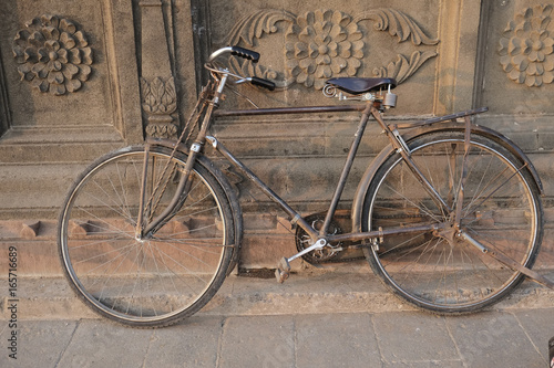 Old indian bicycle leaning on the temple wall.