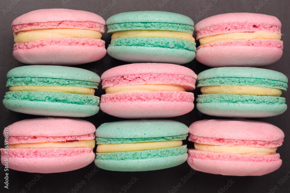 Pink and green colorful macaroons on black background. Flat lay. Top view Pink and green colorful macaroons on black background. Flat lay. Top view