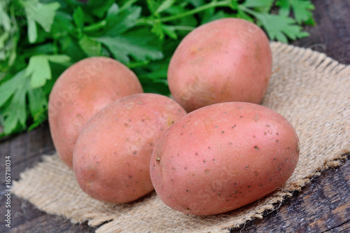 Uncooked red potatoes with parsley on table