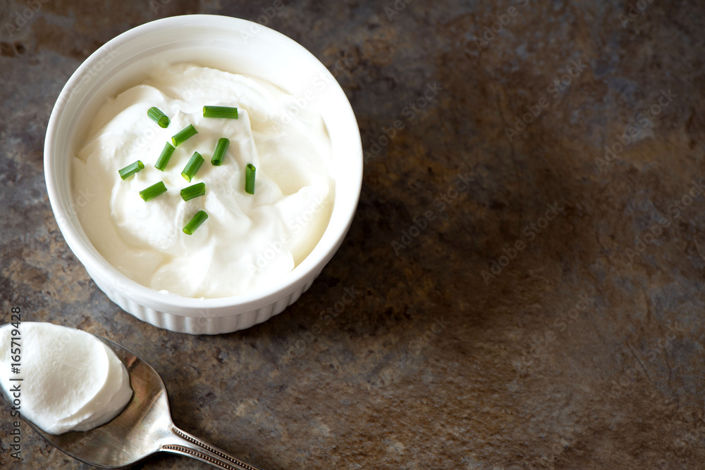 Sour cream in a bowl on brown marble background. Top view with copy space Sour cream in a bowl on brown marble background. Top view with copy space