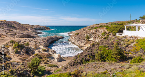Kapros, small bay between rocks and blue sea on Milos island. Cyclades, Greece.
