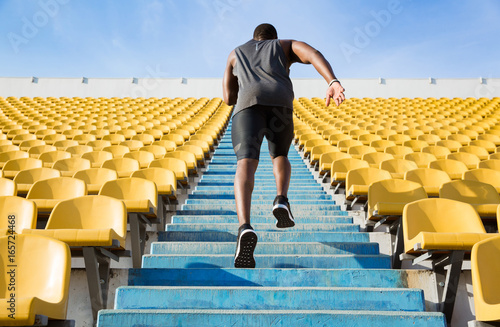 Back view of a young man running upstairs