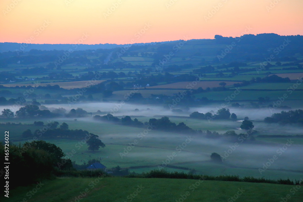 Sunrise on a misty morning over Axe Valley in East Devon, England