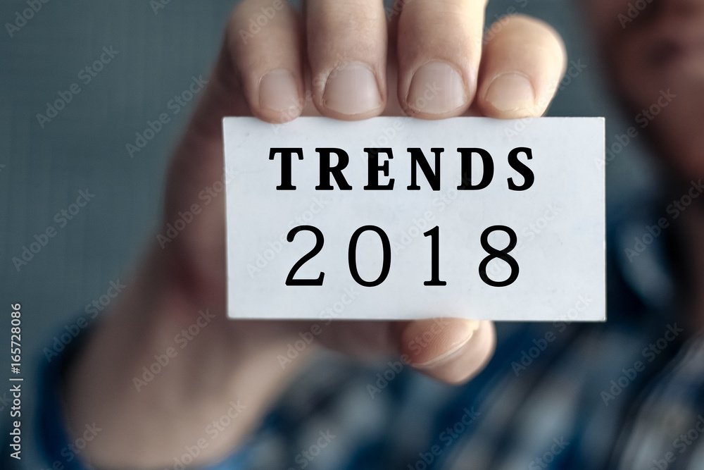 TRENDS 2018, message on white card man showing, may used for different words and background. Aged toned. TRENDS 2018, message on white card man showing, may used for different words and background. Aged toned.