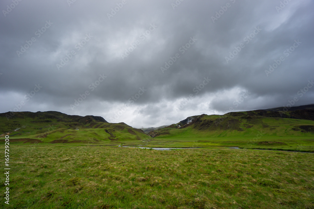 Iceland - River flowing between green volcanic mountains Iceland - River flowing between green volcanic mountains