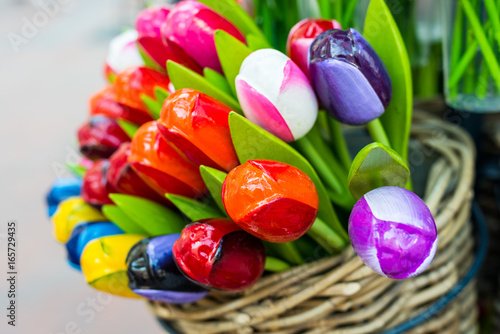 Multicolored wooden tulips in a wicker basket