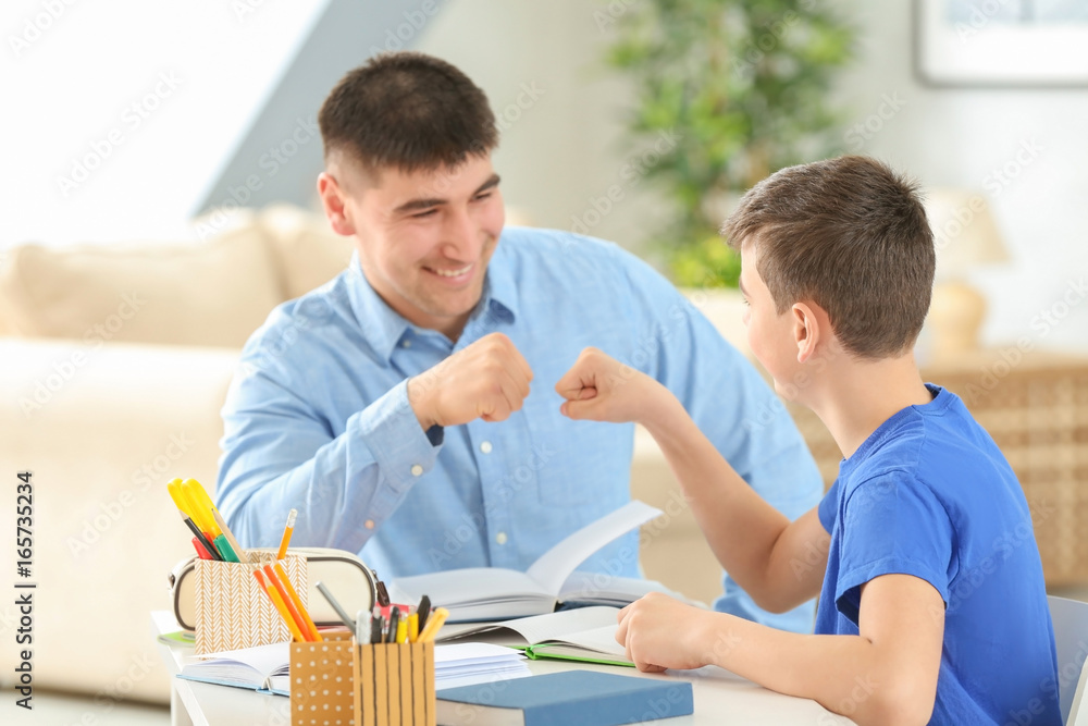 Obraz premium Father and son doing homework together indoors