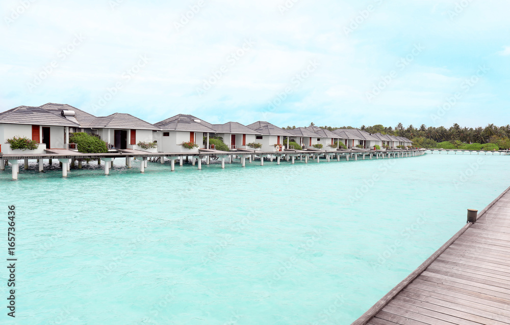View of modern beach houses on piles at tropical resort