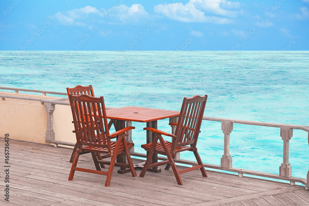 Table and chairs at sea beach on summer day