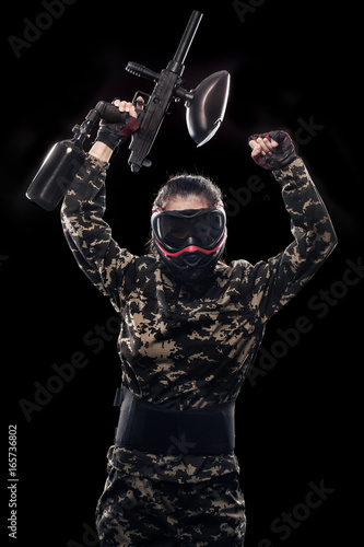 Heavily armed masked soldier isolated on black background. Paintball and lasertag sport games.