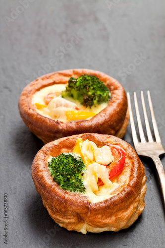 Yorkshire puddings stuffed with broccoli and scrambled eggs on black stone background