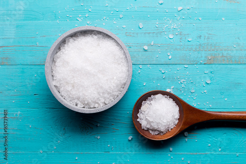 sea salt in bowl and in spoon on wooden background photo