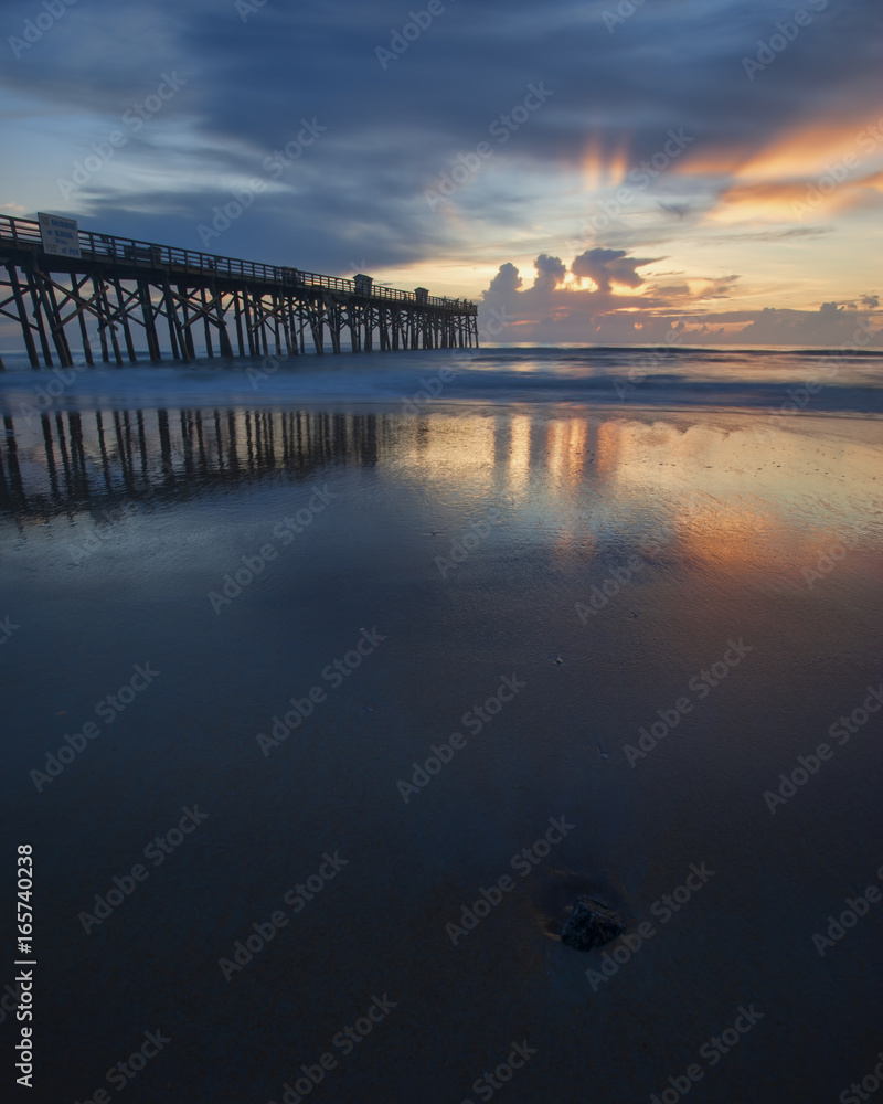 Reflection of sunrise on wet sand.