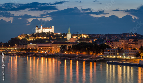 Bratislava castle at night with light reflection on the dunaj river on right riverside.