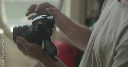 Man uses a digital camera at home for hobby photography.