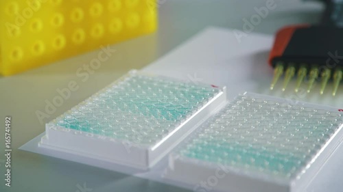 Measuring solutions and reagents: automatic multi-channel dispenser. Equipment for scientific research laboratories and work with reagents. The dispenser is filled with test tubes. photo