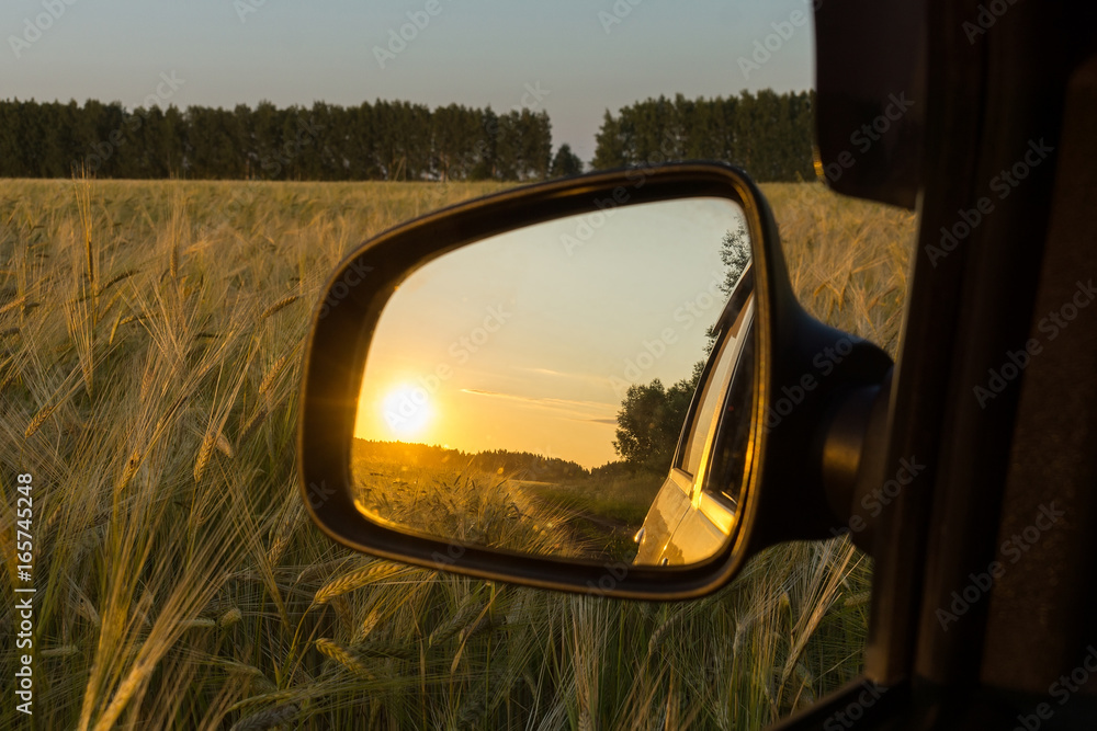 Reflection in the sunset mirror in the wheat field