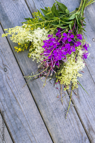 Bouquet of wild summer field flowers on a wooden background
