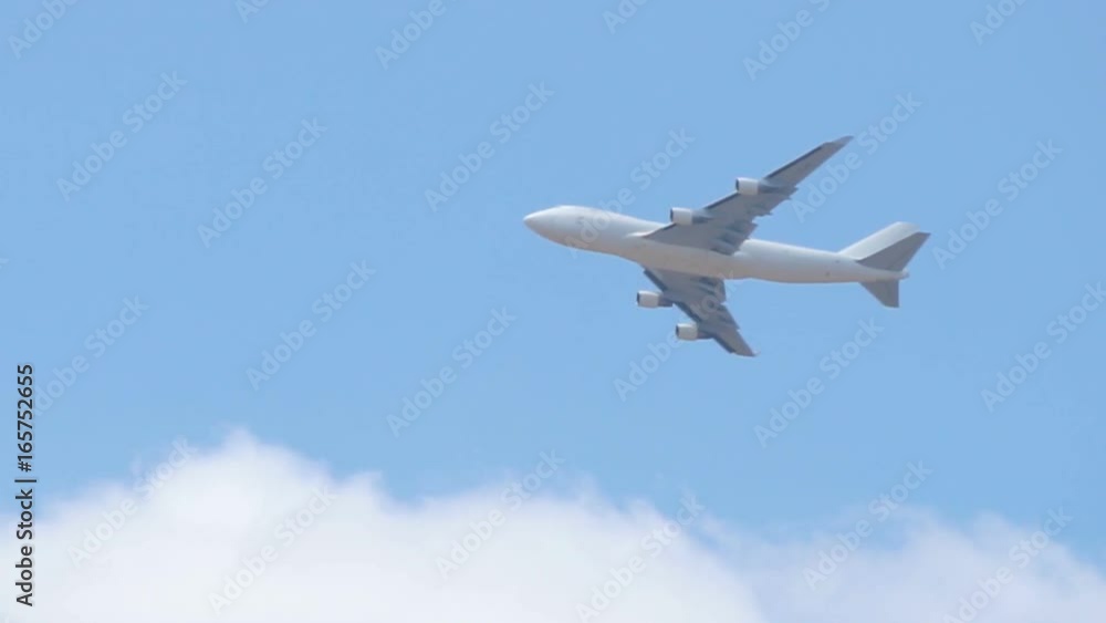 Close up of white cargo airplane passing on blue sky Close up of white cargo airplane passing on blue sky