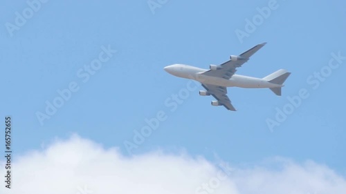 Close up of white cargo airplane passing on blue sky