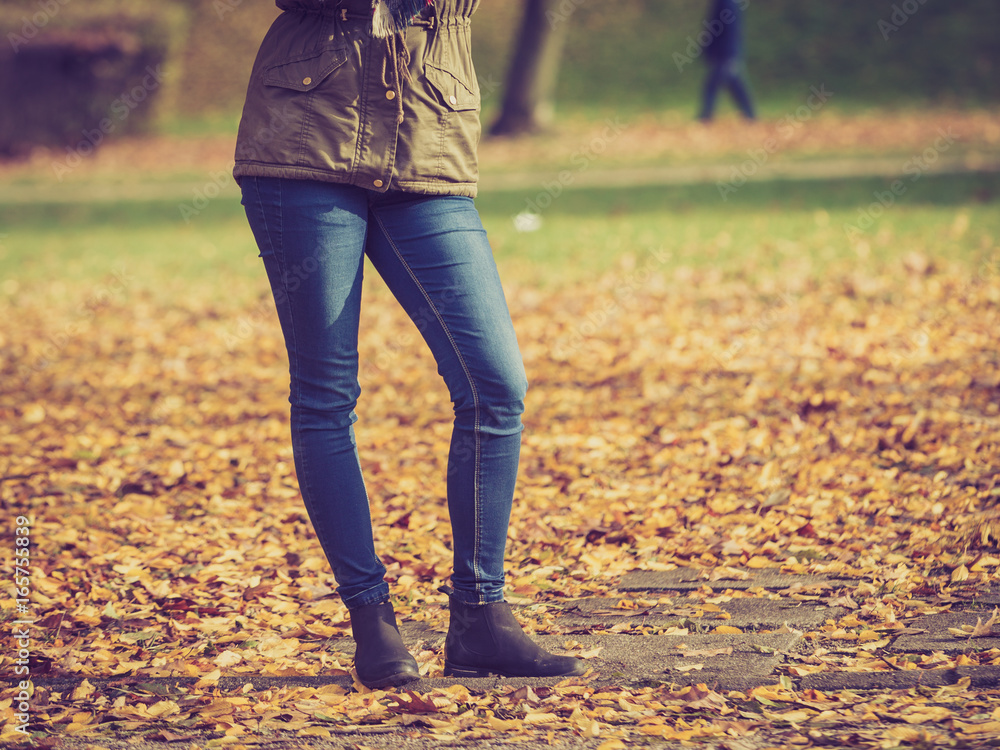 Woman legs standing in autumnal park Woman legs standing in autumnal park