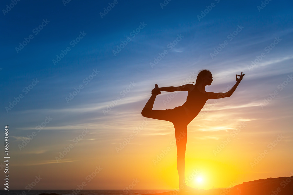 Silhouette of young woman doing fitness exercises on the sea beach during amazing sunset. Yoga and healthy life style. Silhouette of young woman doing fitness exercises on the sea beach during amazing sunset. Yoga and healthy life style.