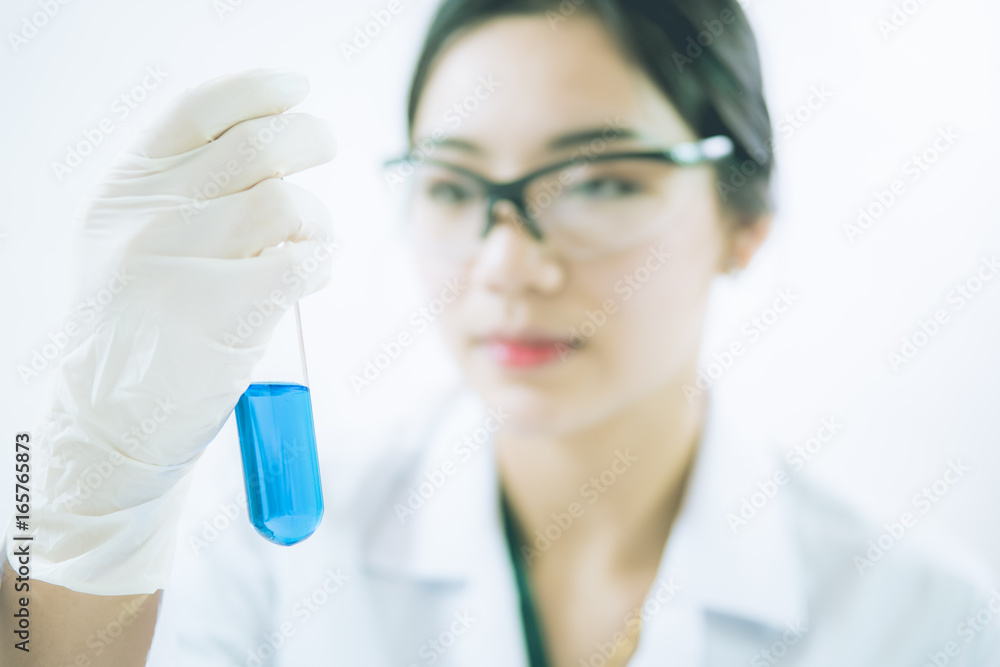 Fototapeta premium Young Asian scientist working in the lavatory with test tubes and other equipment to discover new drugs, products and methods of formulation