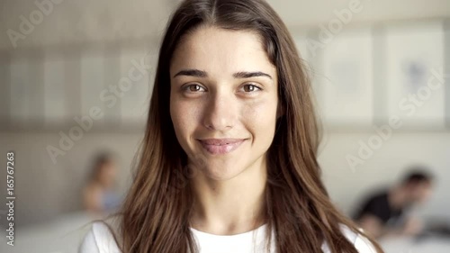 Portrait of a beautiful caucasian smiling laughing girl in bright working studio environment. Woman happy with her job.