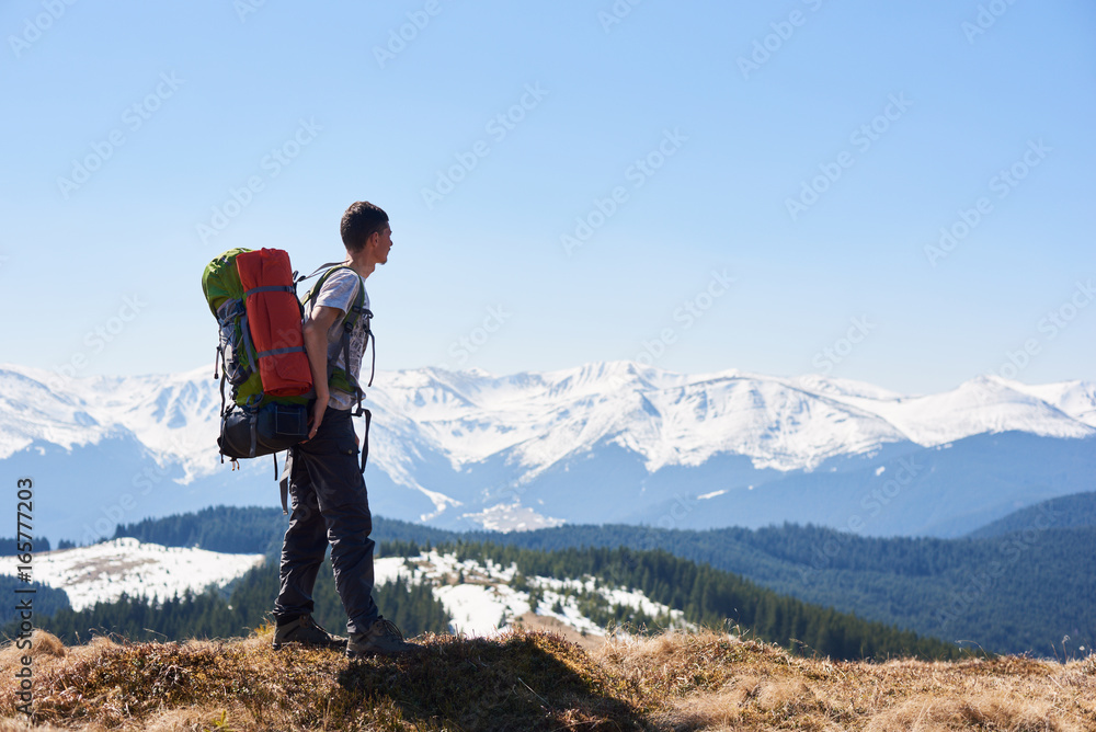 Male hiker with a backpack on his back taking in the view from the top of a mountain copyspace beauty nature landscape hiking travelling active lifestyle concept.