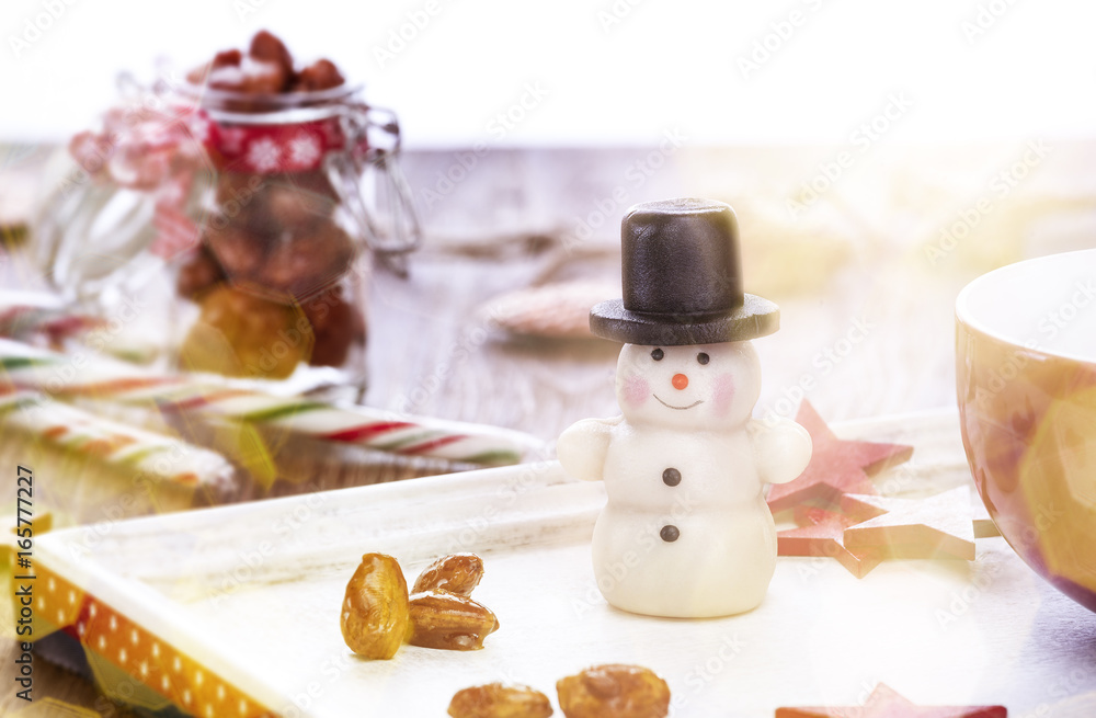 Schneemann confiserie auf einem Tisch mit Tasse, gebrannten Mandeln
