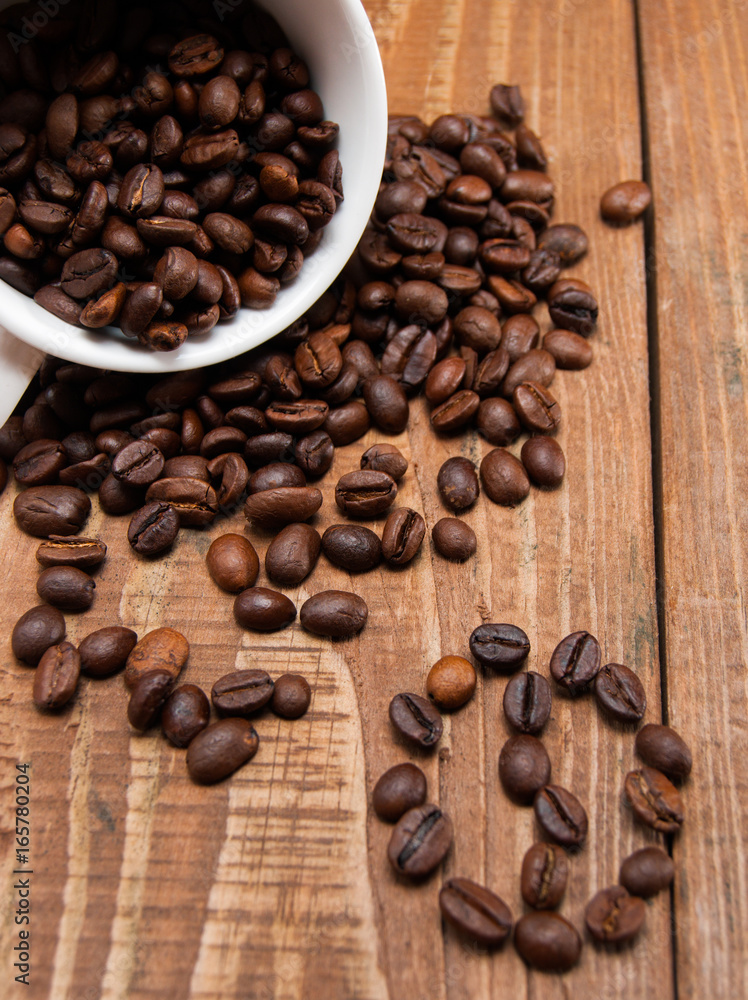 Overturned white cup with coffee beans Overturned white cup with coffee beans