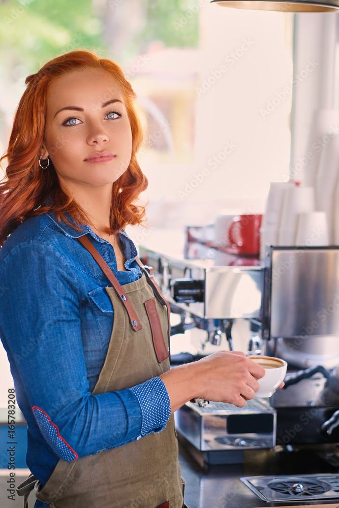 Portrait of redhead female barista drinks coffee. Portrait of redhead female barista drinks coffee.