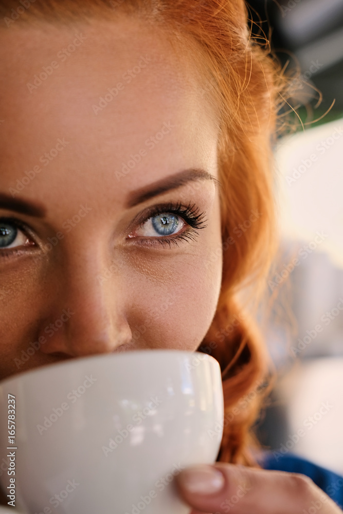 Portrait of redhead female barista drinks coffee. Portrait of redhead female barista drinks coffee.