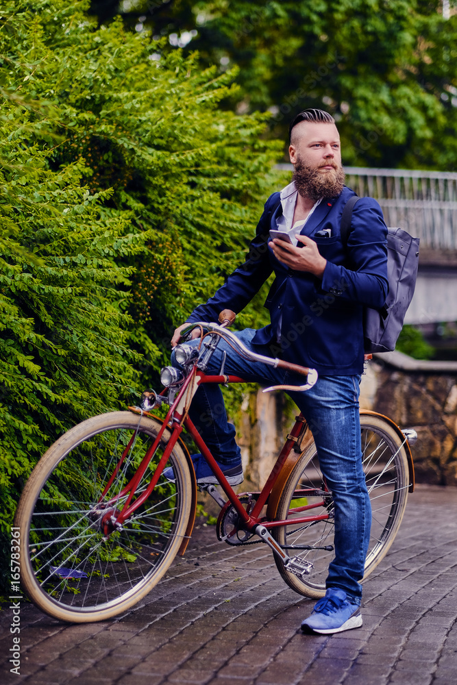 Obraz premium Casual bearded male in a park talks by smart phone.