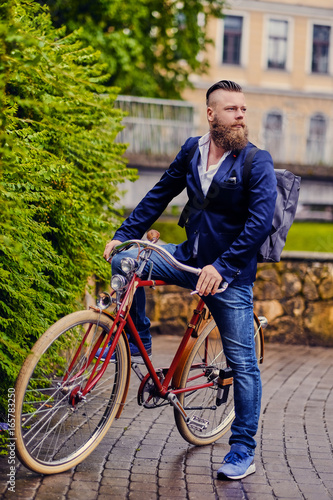 A man on a retro bicycle in a park.