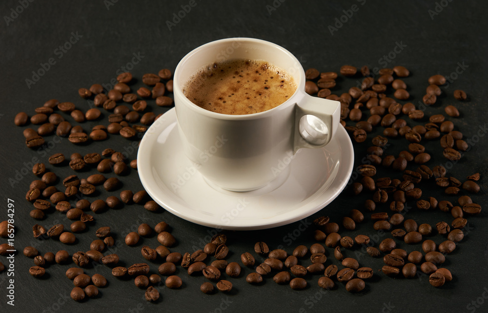 Coffee beans with coffee cup on a dark stone background. Coffee time Coffee beans with coffee cup on a dark stone background. Coffee time
