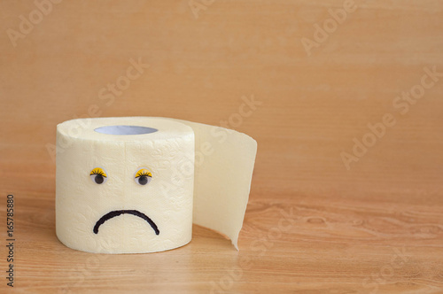 Toilet paper with googly eyes on wooden background. photo