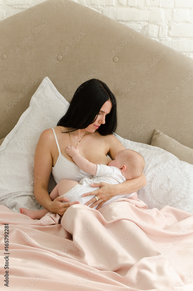 Breastfeeding. Young mother nursing baby. Family at home
