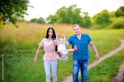 happy family walks in the evening park, amicably embrace and smile