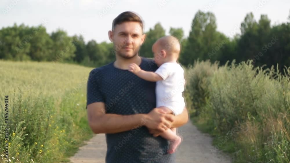 Father holding baby in arms walk in grain culture plain Father holding baby in arms walk in grain culture plain