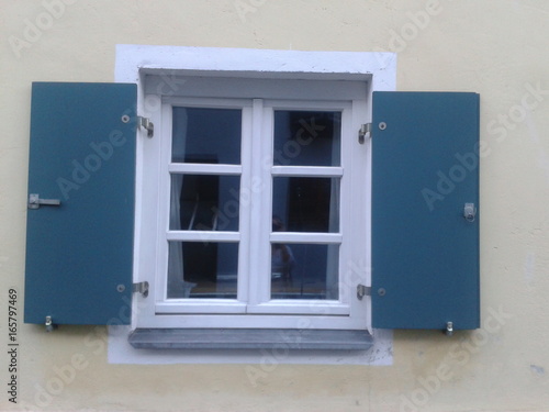 Weißes Fenster mit Fensterläden aus Holz