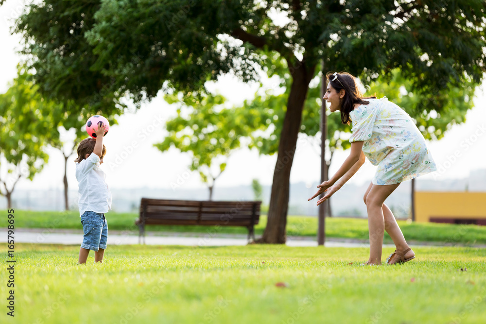 Beautiful young mother with her son having fun in the park. Beautiful young mother with her son having fun in the park.